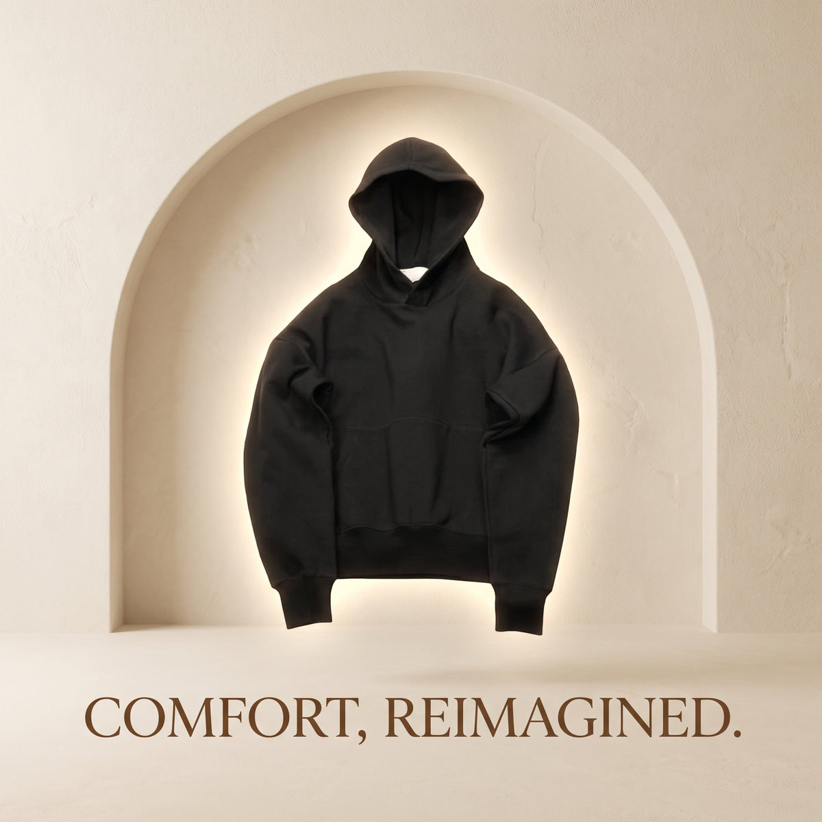 Black HOODÉRA hoodie against a cream arch. Comfort, Reimagined.